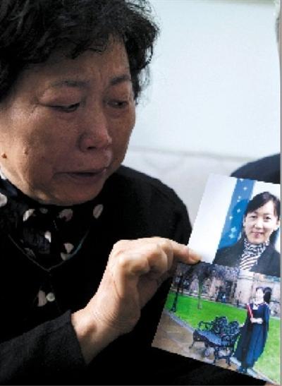 2014年，梁娅母亲手持梁娅生前照片流泪。图/视觉中国